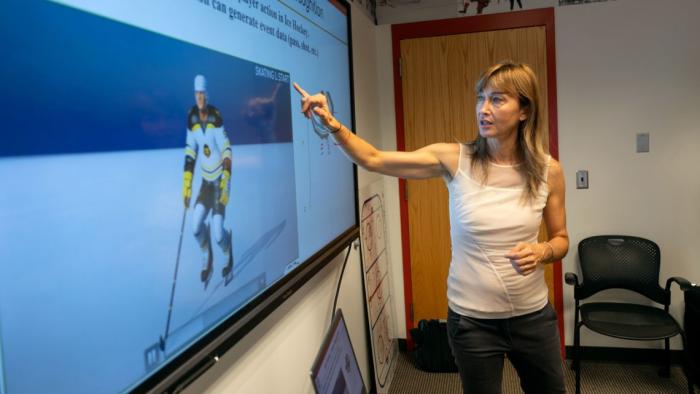 Dr. Silvia Ferrari demonstrates work at a screen with hockey players